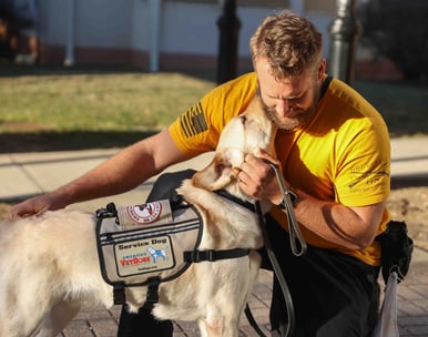 Man sitting next to service dog